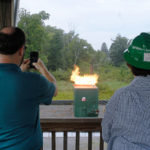 Ladlee and Bubb watch from the control tower as Moore lights another of the facility's realistic props.