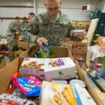 Cadet Michael J. Policare, a heating, ventilation and air conditioning technology student from Allentown, sorts through boxes.