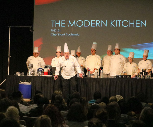 Chef Frank M. Suchwala, associate professor of hospitality management/culinary arts, enthusiastically introduces the morning’s demonstrations.