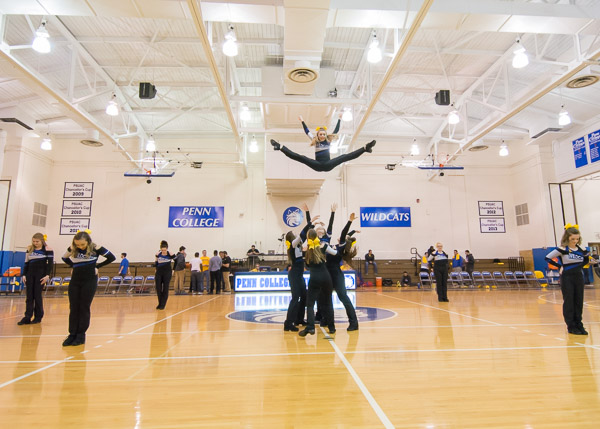 A member of the Wildcat Dance Team is frozen at the peak of gravitational defiance.