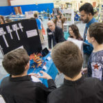 Paul R. Watson II (in blue shirt at right background), Penn College’s dean of academic services and college transitions, helps judge the day's impressive entries.