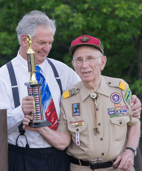 Master of ceremonies William P. Carlucci presents a trophy to event founder