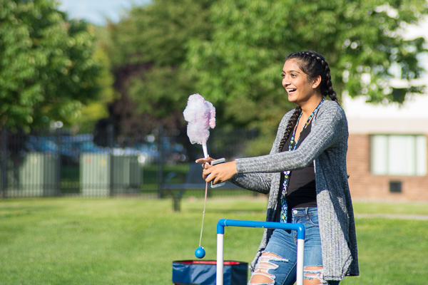 Zeel Patel, a physician assistant student from Bensalem, juggles cotton candy, cellphone and ladder golf.