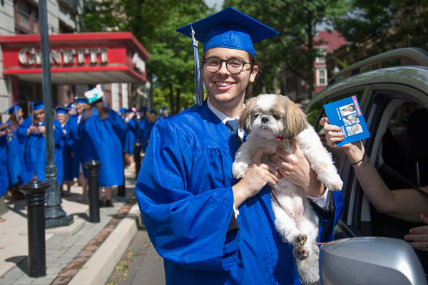Enjoying a drive-by hug from his dog is Jeffrey D. Moore, of St. Marys, health arts: practical nursing emphasis.