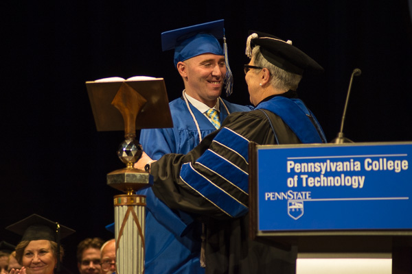 After turning Harer’s tassel, the president gives the student speaker a congratulatory hug.