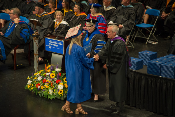 State Rep. Garth Everett, a member of the college’s board of directors, assists in presenting diplomas.
