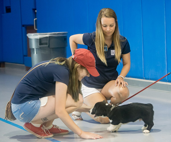 Community Peer Educators Nina L. Walk (left) and Tasia A. Werkmeister enjoy puppy love with