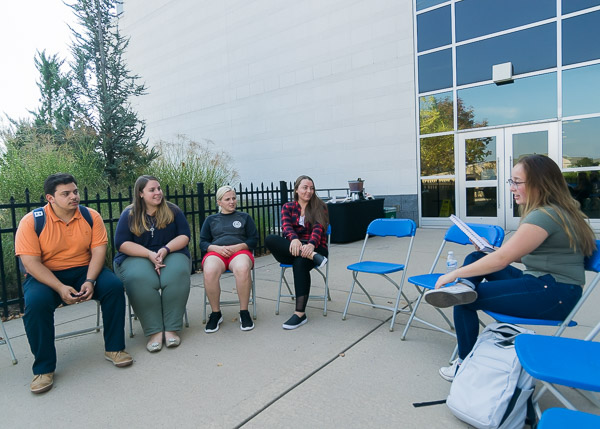 ... facilitates conversation on the Bookmarks Cafe patio outside Madigan Library.