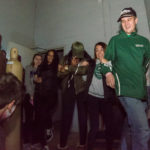 Arms linked in solidarity, an entourage recoils at a jump scare.