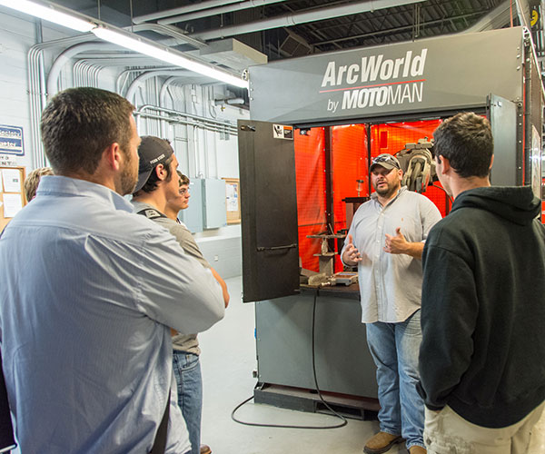 Aaron E. Biddle, instructor of welding, talks about high-tech welding with a high school group in the Avco-Lycoming Metal Trades Center.