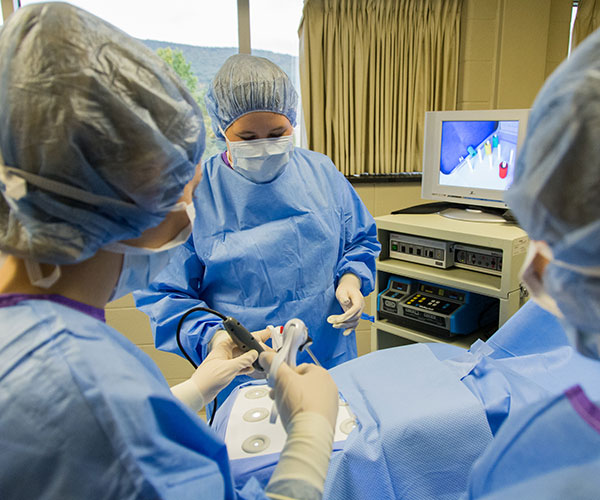 After scrubbing up and gowning, visitors try their hands at laparoscopy in the surgical technology facilities.