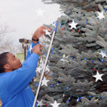 ... and Efrem K. Foster, a nursing student from Williamsport, makes a few adjustments to ensure complete coverage.