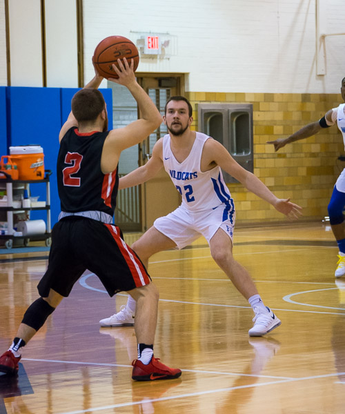 Shooting guard Spencer W. Bartron, the game's high scorer with 20 points, defends against Wells College's' Anthony Nesci.