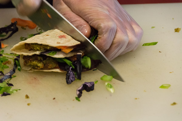 Students assemble falafel taco samples for presentation by Kristin Messner-Baker of The Vegetable Hunter. (The hand belongs to McGlynn.)