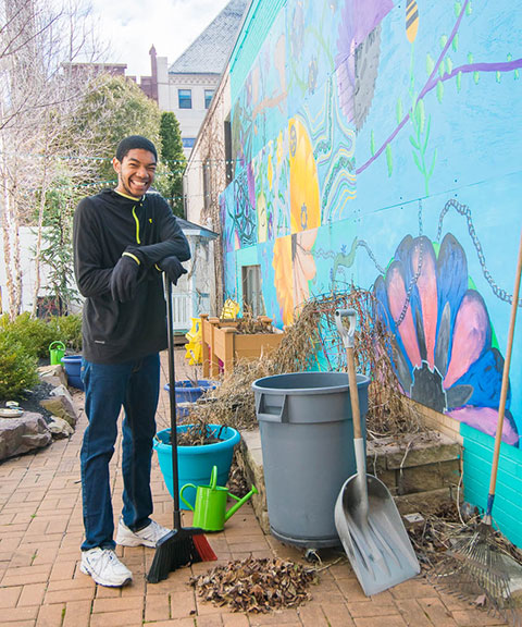 Jonathan P. Bailey, an exercise science student from Philadelphia, helps clean up the children's vegetable garden at James V Brown Library.