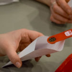 Students measure and pour exactly a quarter-teaspoon of seeds into each packet.
