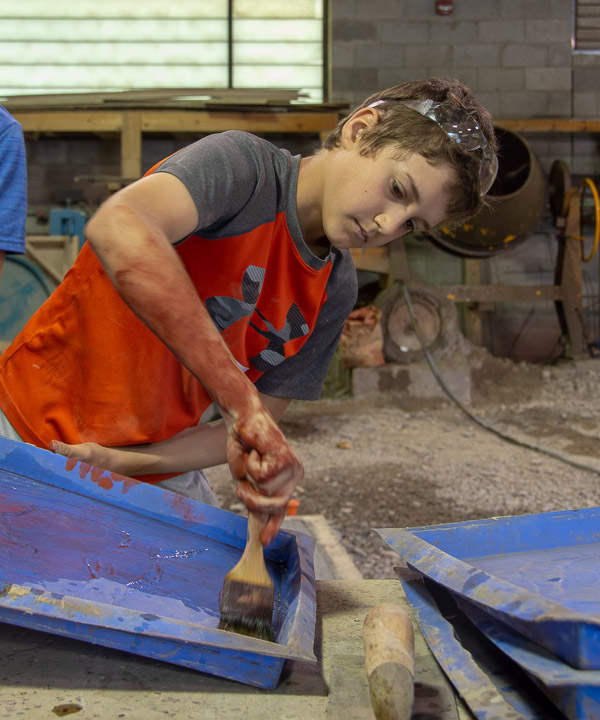 A student from Midd-West Middle School prepares a mold in a session led by Franklin H. Reber that taught them to make concrete stepping stones.