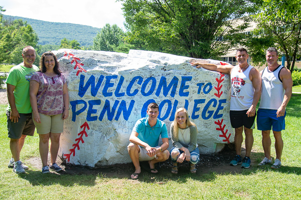 With his team of move-in supporters, Isaac K. Good (center in blue) poses at The Rock, embellished with the signatures of players from the 2018 Little League Baseball World Series teams. Good, of Boiling Springs, is majoring in information assurance and cyber security.