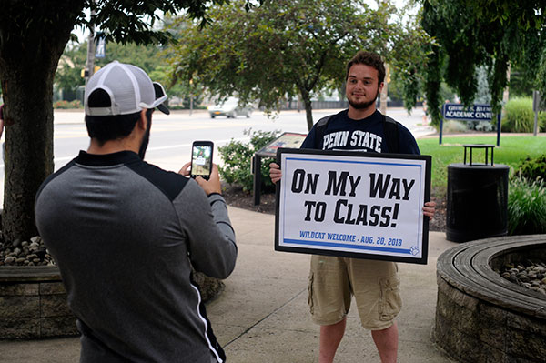 Residence Life Coordinator Jamie R. Miller convinces another Monday volunteer – Joseph M. Sepp, of Johnstown, majoring in heavy construction equipment technology: operator emphasis – that the folks back home will want photographic evidence.