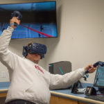 Jack M. Banker, electronics and computer engineering technology, motions wildly as he fights enemies in Superhot VR.