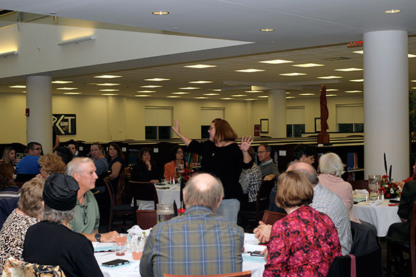Tracey Amey, library director, welcomes the evening's sellout crowd and outlines the entertainment to come.