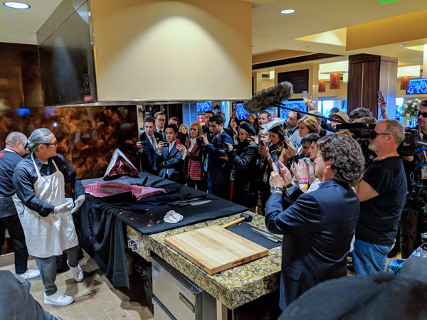 Chef Takao Iinuma (far left) and Chef Masaharu Morimoto attract a crowd of cameras as Morimoto offers a demonstration.