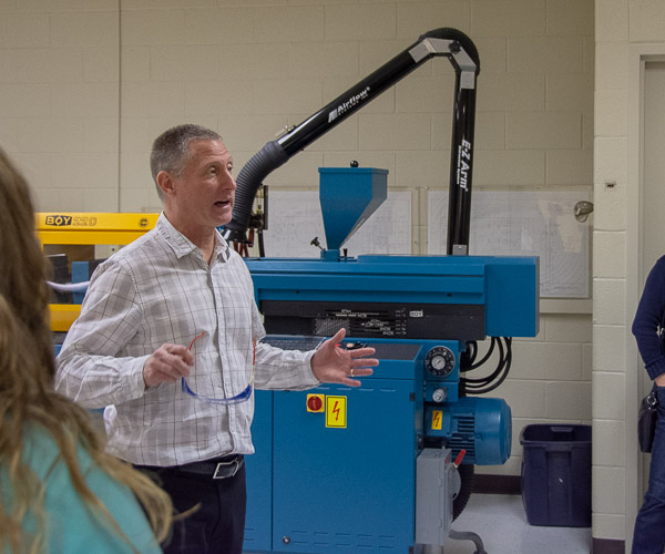 In an injection molding lab, Kirk M. Cantor, professor of plastics technology, introduces a group to the field plastics and polymer engineering technology.