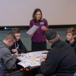 Alicia McNett, instructor of computer information technology, offers encouragement to a group of students from Milton High School.