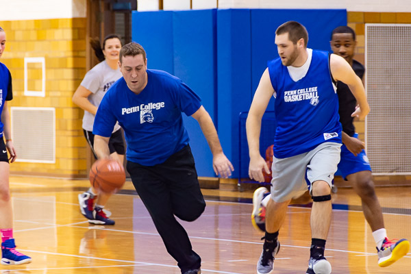 2007 grad Anthony R. Flint (with ball) and Joseph J. Simon (Class of 2010) hustle upcourt; both earned degrees in business administration: management information systems concentration.
