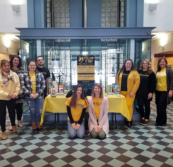 Student Activities representatives, attired accordingly, surround a Yell(ow)-It-Out table in the Bush Campus Center.