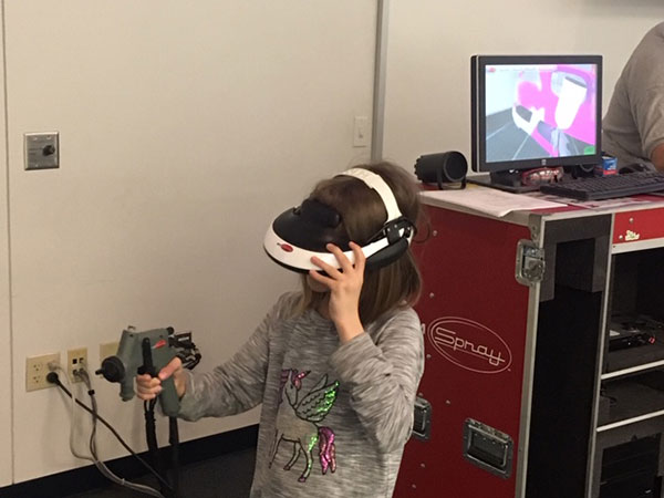 A young visitor tries her hand at virtual paint-spraying.