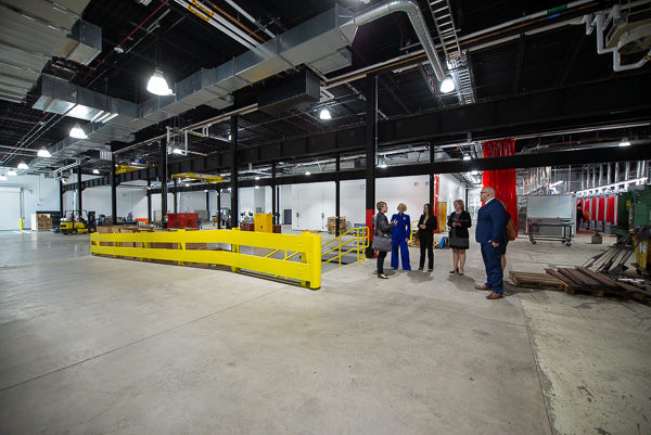 Loni N. Kline, vice president for institutional advancement, leads the group through the college's welding addition.