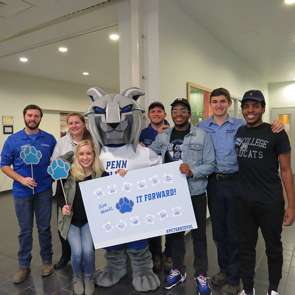 Joining the Penn College Wildcat in urging their peers to "Give Thanks, Paw It Forward" are (from left) Student Development Assistants Wesley S. McCray, an engineering design technology major from Corry; Mary C. Watts, of Quakertown, information assurance and cyber security; Jordyn M. Kahler, of York, dental hygiene, Jonathan R. Hendrickson, of Cowansville, software development and information management; Miles K. Lampkin, of Horsham, software development and information management; Andy P. Luzeckyj, of Southampton, automotive technology management; and Malcolm K. Lampkin, of Horsham, and in the same major as his twin brother.