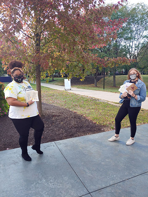 The Wildcat Events Board's Shaqira S. Drummond (left) and Caila N. Flanagan show off their personalized cards. The Williamsport residents are both business administration majors, Drummond in the marketing concentration and Flanagan in management.