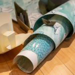 Paper teacups and boats intermingle in a chaotic array with the artist's prints.