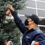 Placencia, an Army ROTC cadet who will be commissioned as a second lieutenant later this month, affixes a ball filled with ribbons from a prior year's fundraiser.