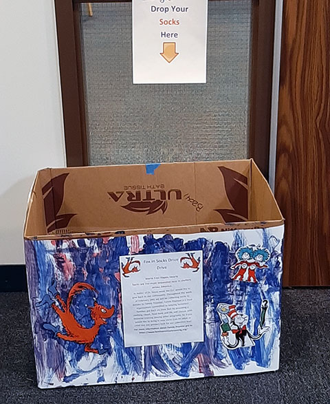 A toddler-created collection box stands ready for donations in the LEC hallway outside the child care center.