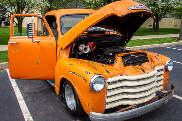 A Chevy truck displays multiple layers of paint, each with a story to tell.