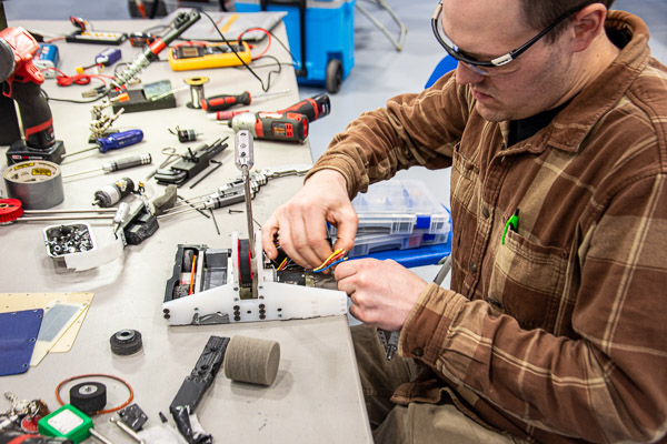 Kyle D. Singer, a former SWORD officer, makes repairs to his bot, Dain.