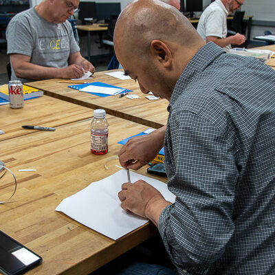 Qiang Cao, assistant professor of radiography, adds copper tape to create a circuit connecting his card’s LEDs to a battery.