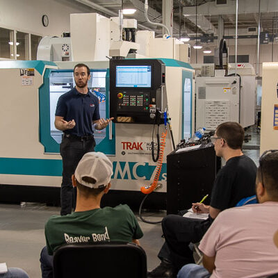 Kevin Callahan, applications representative for Trak Machine Tools/Southwestern Industries Inc., walks students through the features of a new Trak CNC Vertical Machining Center in the Automated Manufacturing Lab.