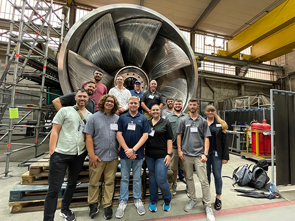 The Penn College students strike a pose in front of a hydroelectric turbine blade during a tour of Voith Hydro in Heidenheim, Germany. Voith Hydro is a leading producer of hydroelectric power turbine systems. 