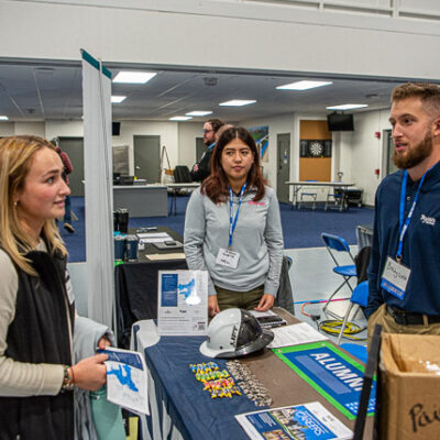 Savannah J. Zimmerman, a residential construction technology management student from Dallas, stops by the NVR Inc./Ryan Homes booth to talk with Rebecca Rosette and alumnus Brady T. Wolfe. Wolfe holds two degrees from Penn College: building construction technology (2021) and residential construction technology management (2022).
