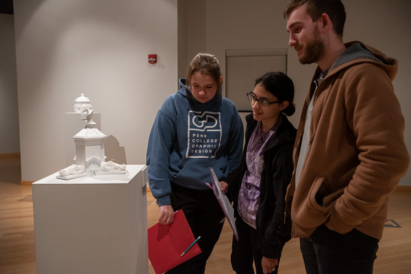 Considering one of the exhibit’s sculptures are graphic design seniors Katrina L. Blood (in blue sweatshirt) and Jessica D. Aviles; along with Aviles’ husband, Ben G. Pace, ‘21, industrial design.
