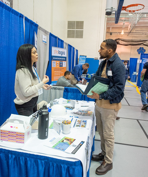 In Bardo Gym, Zavon M. Harris, electrical technology student from Williamsport, converses with Mayra Barcus of Trotter Management Services.