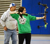 A young archer is instructed by Penn College assistant coach Brian Parker