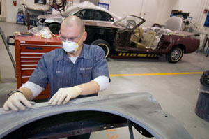 Daniel J. Walsh, an automotive technology management major from Absecon, N.J., preps a door panel from a 1965 Ford Mustang in Pennsylvania College of Technology%E2%80%99s collision repair laboratory. Walsh and three classmates, along with instructor Roy A. Klinger, are restoring the vehicle (visible at background) for the Antique Automobile Club of America%E2%80%99s museum in Hershey. (Photo by Larry D. Kauffman, digital publishing specialist)