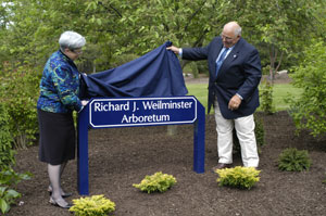 Pennsylvania College of Technology President Davie Jane Gilmour and Richard J. Weilminster unveil the sign denoting dedication of the 5-acre arboretum.