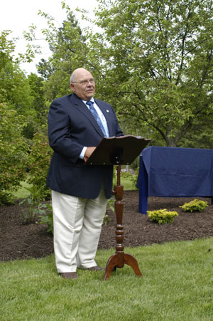 Standing amid abundant greenery, in what once was his 'classroom,' Richard J. Weilminster delivers emotion-tinged remarks at Wednesday's ceremony.