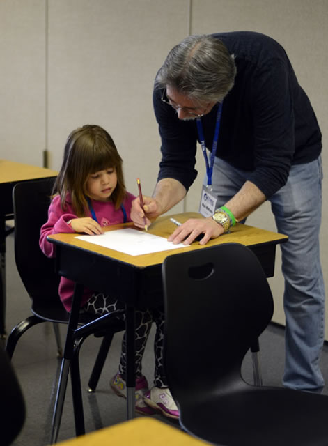 Mark McKenna offers a young artist some hands-on assistance during a "Drawing Your Banana Tail" workshop in the Campus Center.